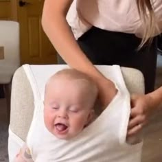 a baby in a chair being held by a woman