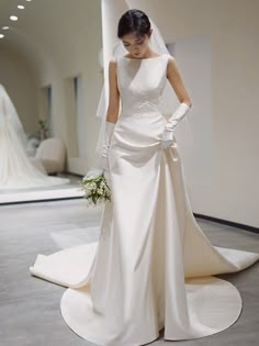 a woman in a white wedding dress standing on the floor next to a mannequin