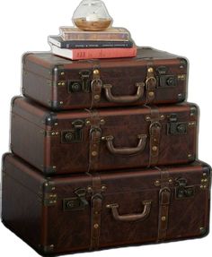 three suitcases stacked on top of each other in front of a stack of books