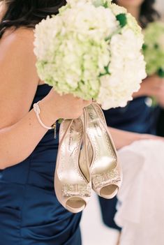 the bridesmaids are holding bouquets and high heeled shoes in their hands