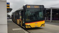 a yellow and black bus parked at a bus stop