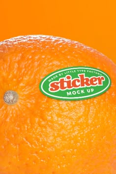 an orange with the sticker mock up on it's side is shown in front of an orange background