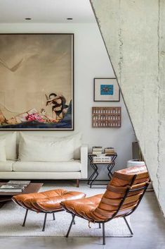 a living room filled with furniture and a painting on the wall