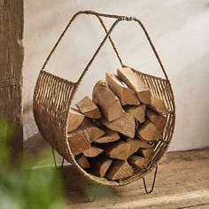 a basket filled with wood sitting on top of a wooden floor