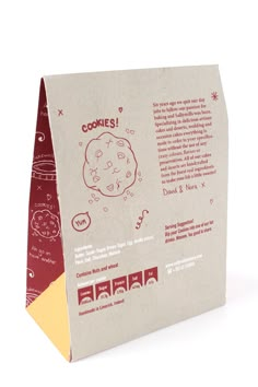 a brown paper bag with red and white designs on it's side, containing an image of a cookie