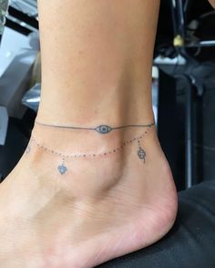 a woman's foot with an eye tattoo on the side of her leg,