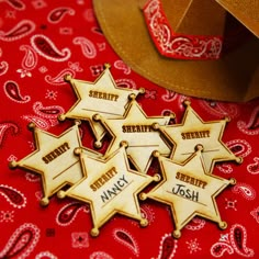 five wooden sheriff badges sitting on top of a red bandanna