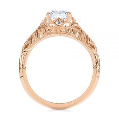 an antique style engagement ring with a center stone and filigrees on the sides