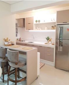 a kitchen with two stools and a refrigerator