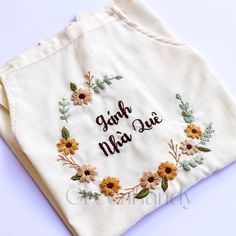 embroidered cloth with words and flowers on it