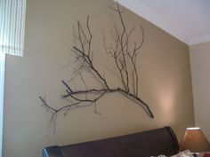 a bedroom with a bed and a painting on the wall above it that says dead tree branches