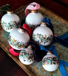 christmas ornaments with ribbons and bows on a tray