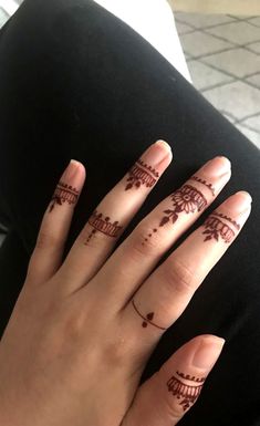 a woman's hand with henna tattoos on it