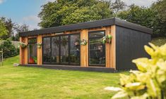 a small black building sitting on top of a lush green field