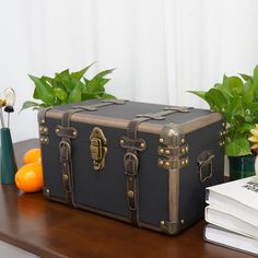 an old suitcase sitting on top of a table next to some books and flowers in vases