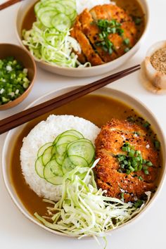 two bowls filled with rice, meat and veggies next to chopsticks