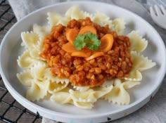 a white plate topped with pasta covered in sauce