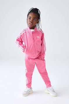 Some pieces never go out of style. This kids adidas track suit reimagines a wardrobe staple for a new generation. The embroidered Trefoil and 3-Stripes down the sleeves and legs connect them to decades of athletes and game changers. In smooth tricot teams up with a loose, everyday fit, this look is poised to become their go-to for casual hangouts and adventures. When heritage-inspired style is this comfortable, the only thing left is for them to make their own iconic moments. This product is mad Adidas Tracksuit Outfit, Sst Tracksuit, Pink Tracksuit, Tracksuit Outfit, Iconic Moments, Adidas Tracksuit, Adidas Track Suit, Adidas Track