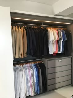 an organized closet with shirts and pants