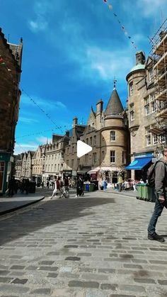 a man is walking down the street in front of some buildings with scaffolding on them