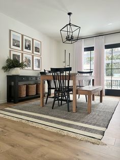 a dining room table with four chairs and a rug on the floor in front of it