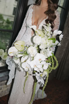 a woman in a wedding dress holding a bouquet of flowers