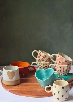 a wooden tray topped with cups and saucers