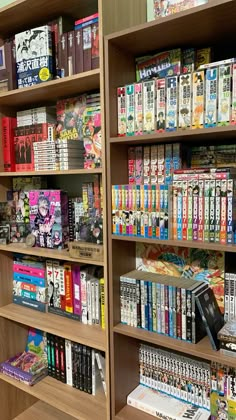 a book shelf filled with lots of books on top of wooden shelves next to each other