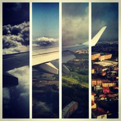 the view from an airplane window shows clouds and buildings