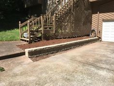 a driveway with steps leading up to a garage door and a fenced in area