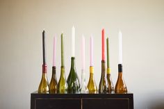 several bottles with candles in them are lined up on a table next to each other