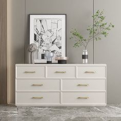 a white dresser with two vases and a plant on top in a gray room