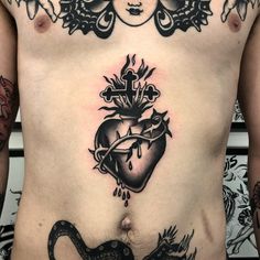 a man with tattoos on his stomach has a heart and snake tattoo on his chest