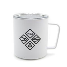 a white coffee mug with black and white geometric designs on it's side, in front of a white background