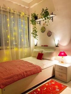 a bed room with a neatly made bed next to a window and a red rug