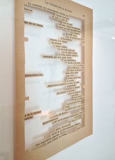 a piece of paper with words written on it hanging in a glass case against a white wall