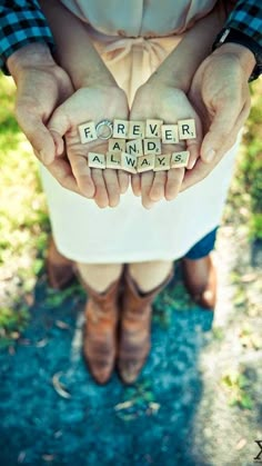 a person holding scrabbles that spell out the word forever and always in their hands