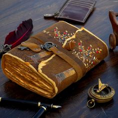 an old book is sitting on a table with other items around it, including pens and ink