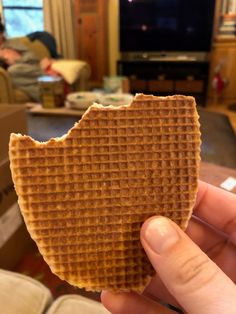 a person holding up a waffle in front of a tv