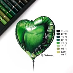 a drawing of a heart shaped balloon with the colors green on it and some crayons next to it