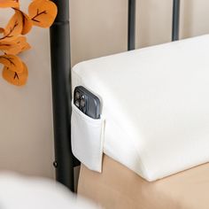 a close up of a cell phone in a pocket on a bed with a pillow