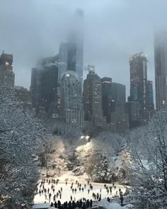 people are skating on an ice rink in the middle of a large city with tall buildings