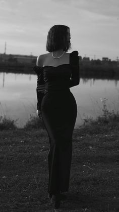 black and white photo of woman in evening dress looking at the water's edge