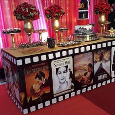 a table topped with movies and desserts on top of a red carpeted floor