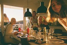 a group of people sitting around a table with plates and glasses on top of it