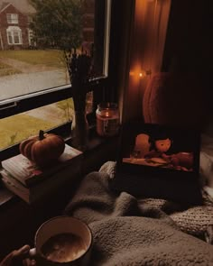 a cup of coffee sitting on top of a window sill next to a book