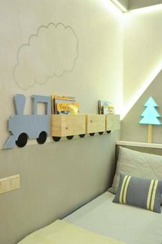 a child's room with a bed, book shelf and toy train on the wall