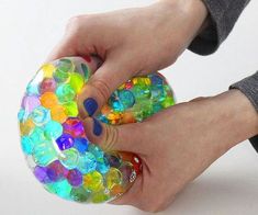 a person holding a colorful object in their hand and touching it with the other hand