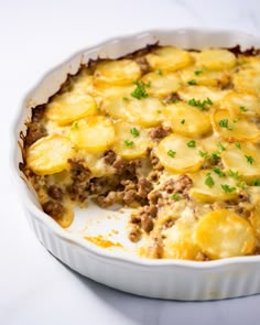 a casserole dish with potatoes and meat in it on a white counter top