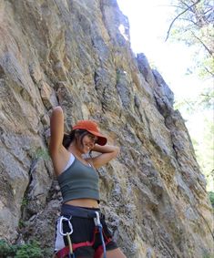 a woman climbing up the side of a mountain